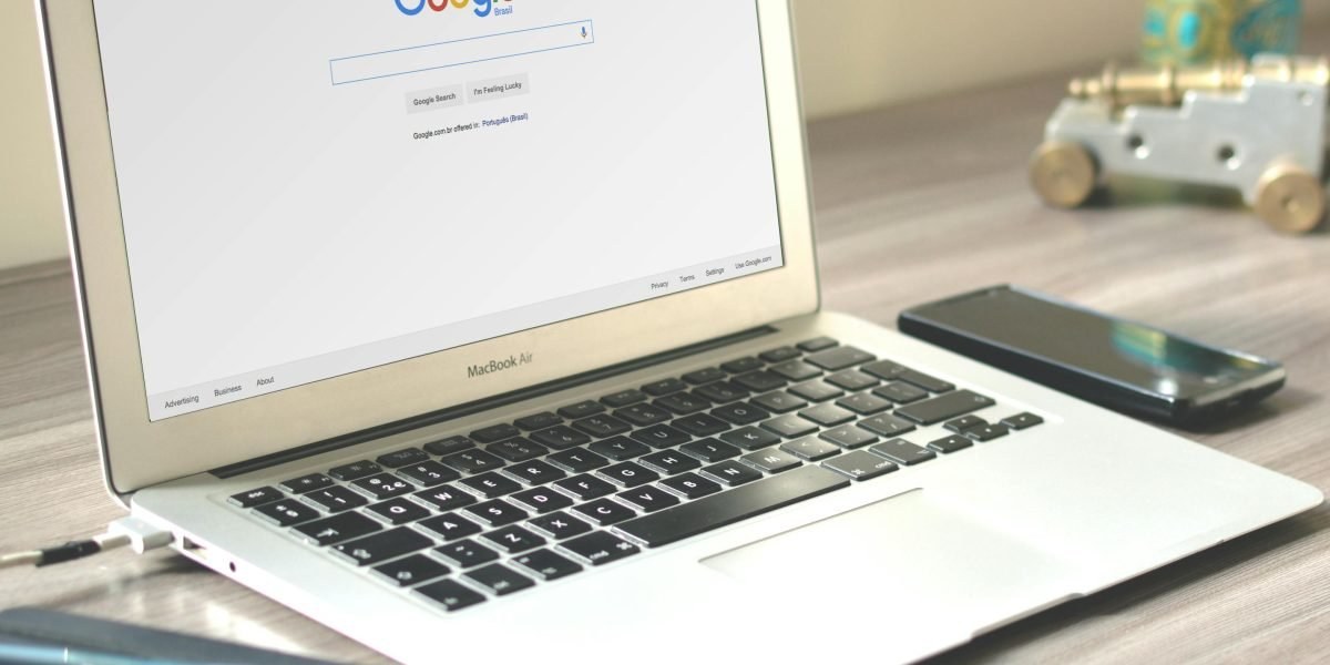 Workspace with laptop and smartphone showing consumer technology headlines