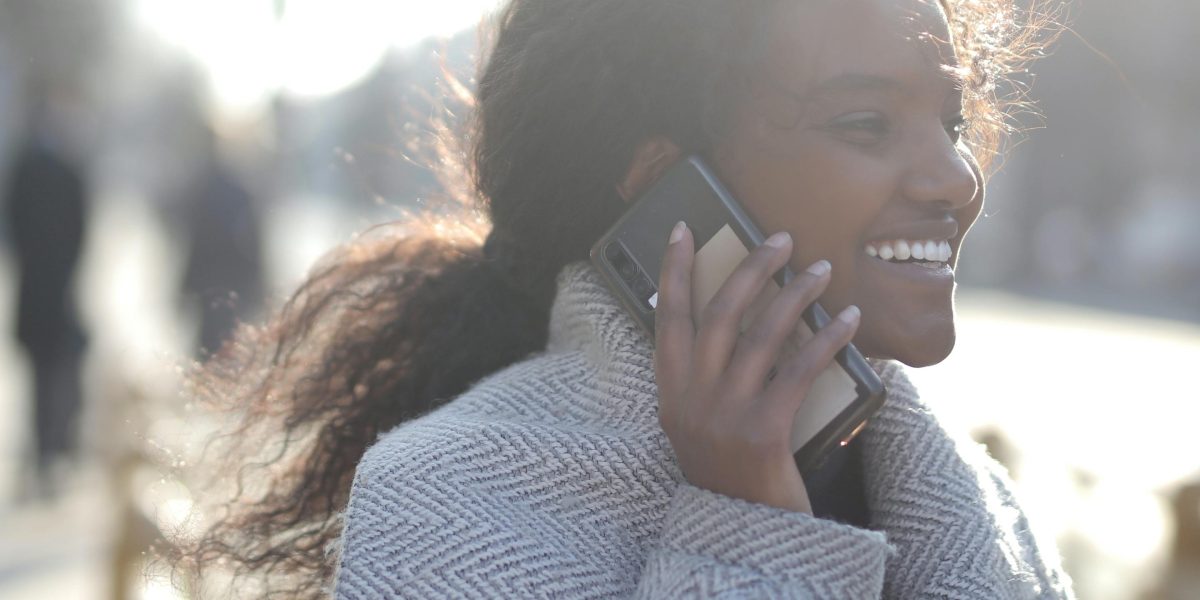 A person confidently using their smartphone outdoors throughout the day, unconcerned about battery life.