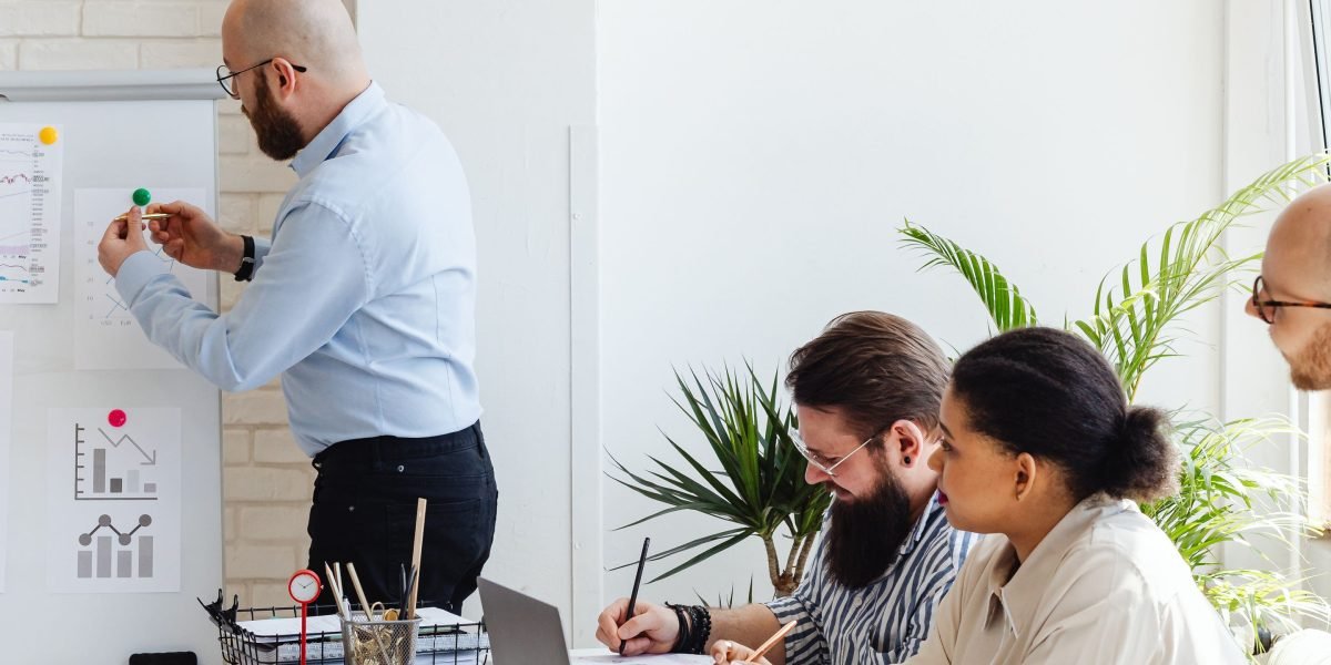 A diverse team actively collaborating in a modern office, symbolizing the interconnected efforts of large corporations.
