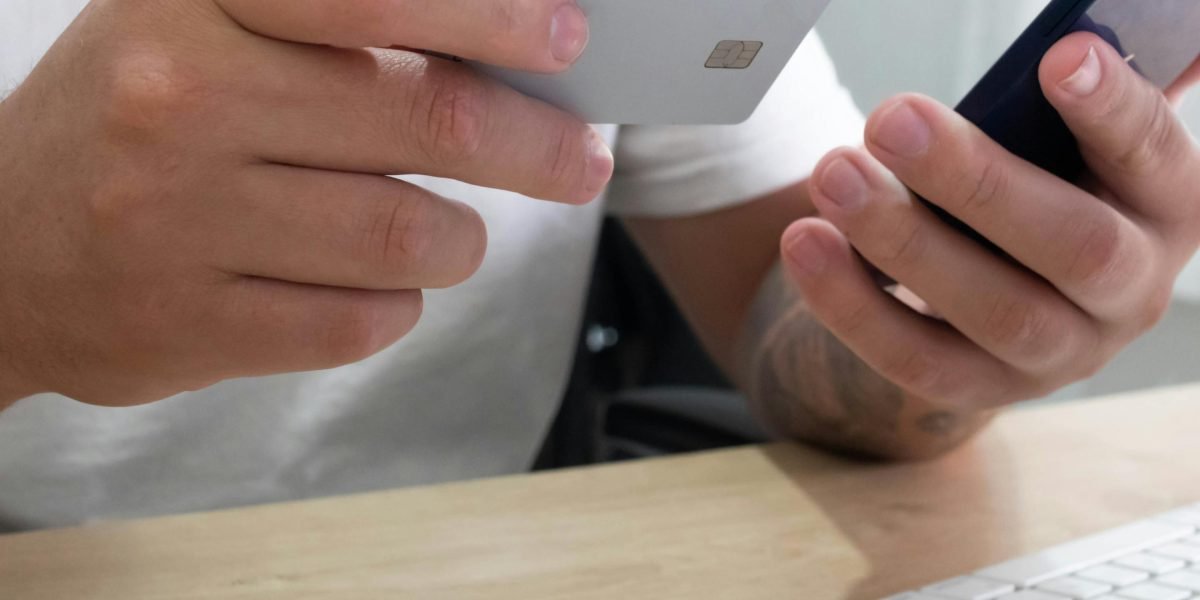 A person appears worried while looking at a mobile device, symbolizing concerns about digital security on outdated software.