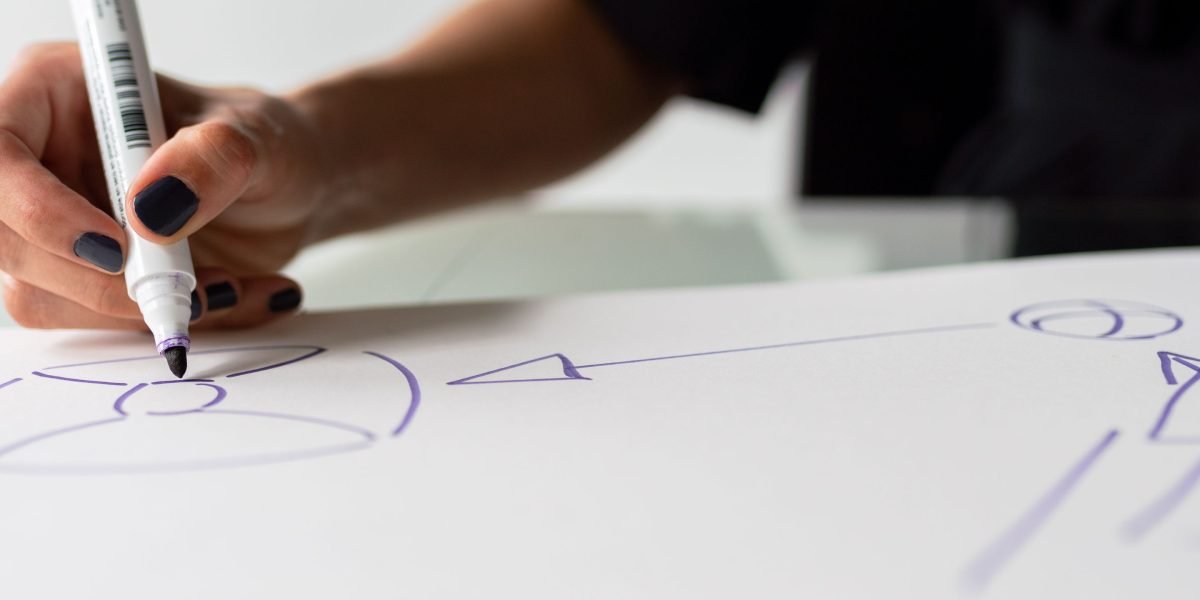 A person actively planning and organizing concepts on a whiteboard, symbolizing thoughtful device layout design.