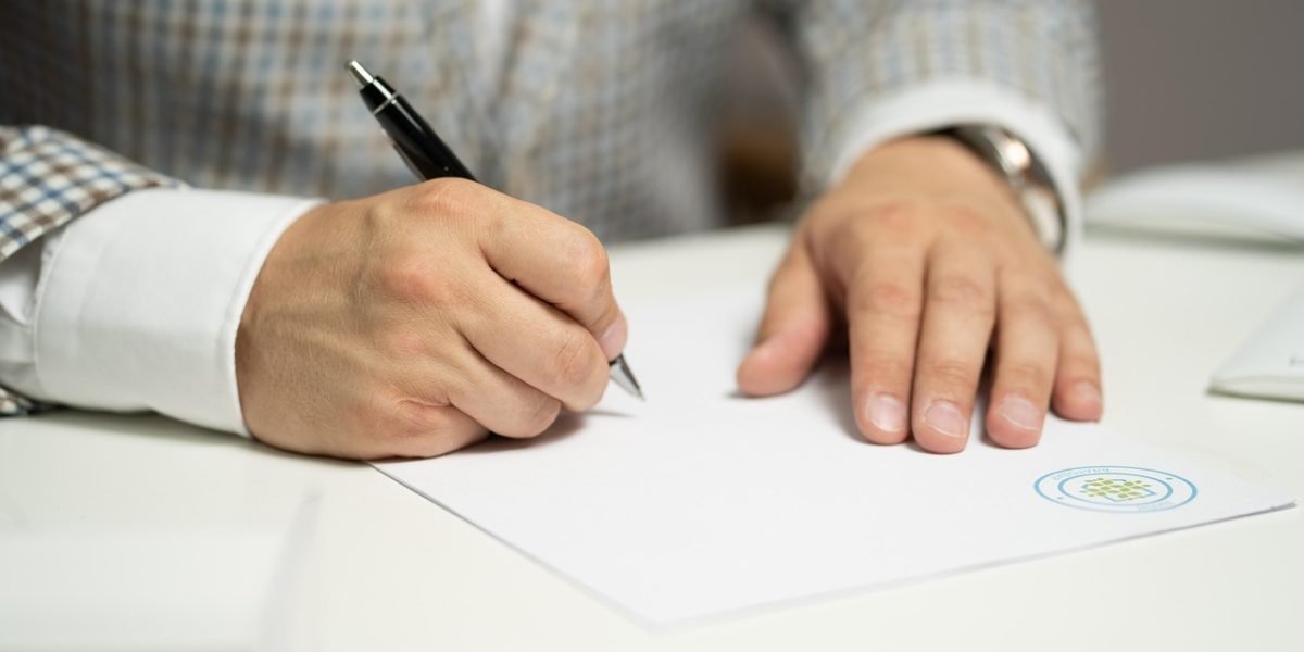 A person meticulously comparing details on a document or screen, symbolizing verification of information.