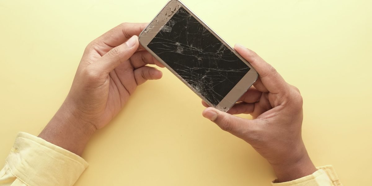 A person observes their smartphone screen, potentially noticing a faint ghost image or discoloration indicative of screen burn-in.