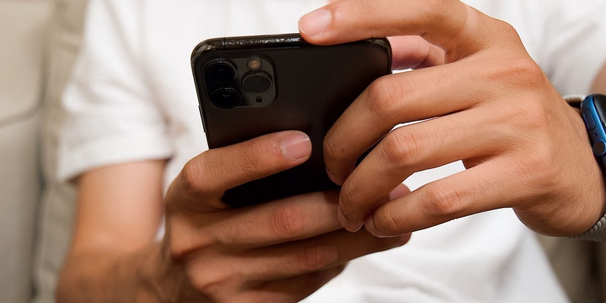 A person adjusting settings on a mobile device, likely optimizing their smart home network for better Wi-Fi performance.