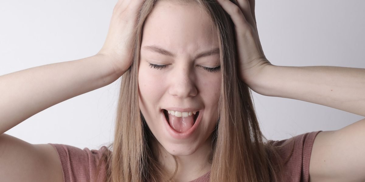A person looks stressed, surrounded by digital and physical documents, symbolizing information overload.