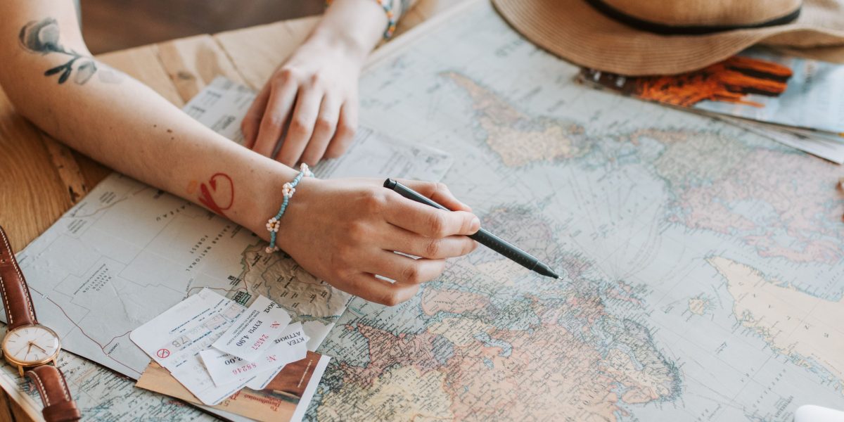 A person looks at a world map, reflecting on their journey and future ambitions.