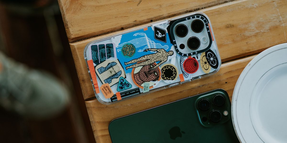 A person carefully considering their options when choosing a new phone case.