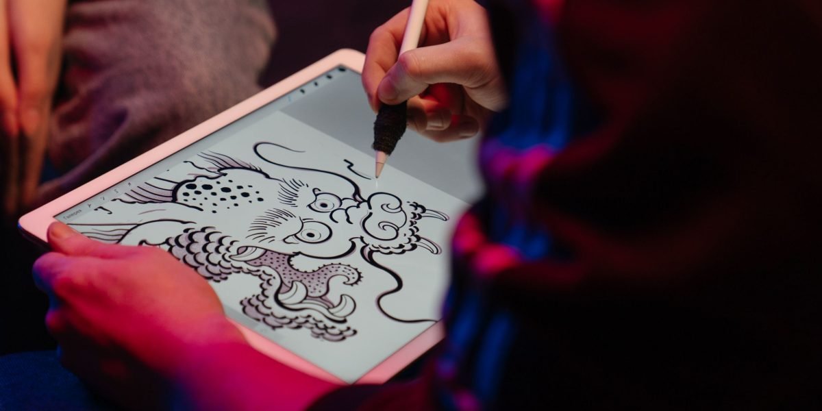 A person engaged in creative work on a tablet, illustrating the versatility and power of modern mobile devices for artistic expression.