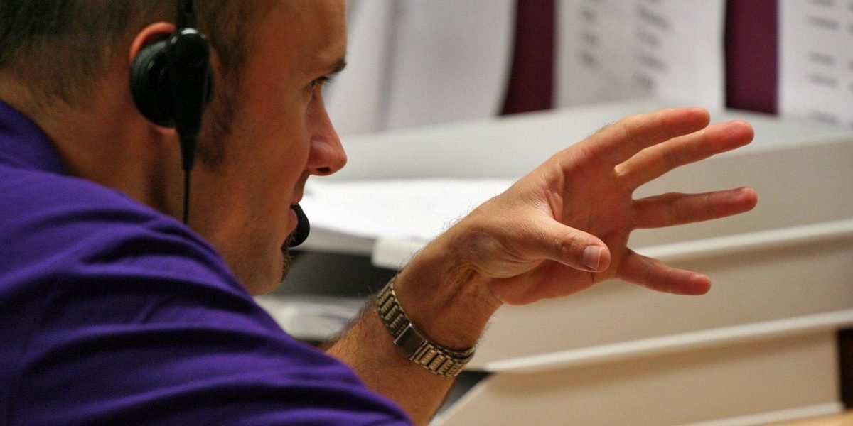 A person thoughtfully examining their phone, representing considerations for privacy settings and in-game purchases.