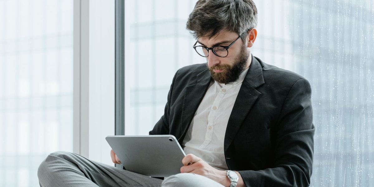 A person staying focused and informed by reading on a tablet, symbolizing managing information overload.