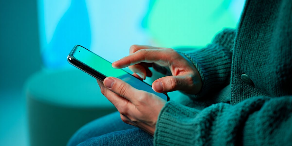 A person intently reviewing privacy settings on a smartphone, emphasizing the user's role in managing data security.