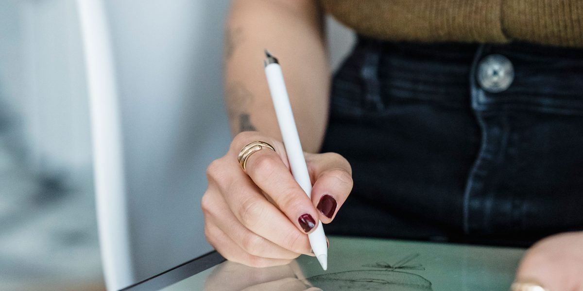 An artist focused on their tablet, utilizing a stylus for detailed creative work, demonstrating the tablet's capabilities for design.