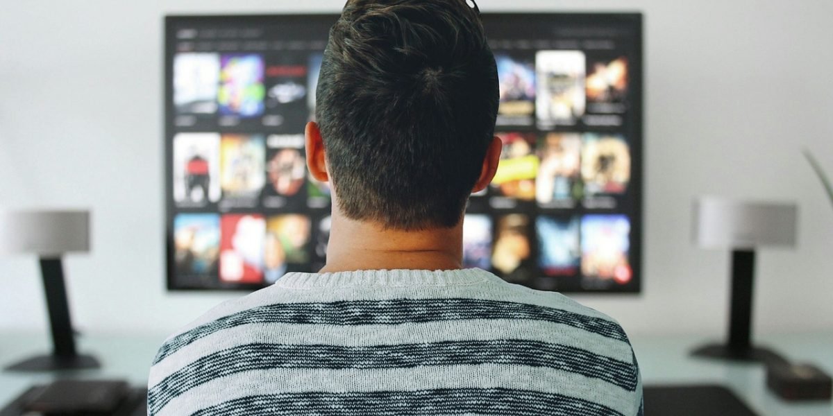 A person navigating content on a smart TV or streaming device, symbolizing the shift to personalized online entertainment.