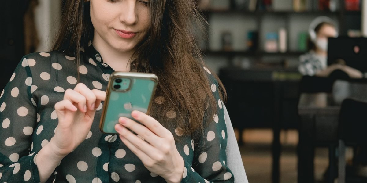 A person confidently using an older smartphone, demonstrating that functional devices can still meet daily needs.