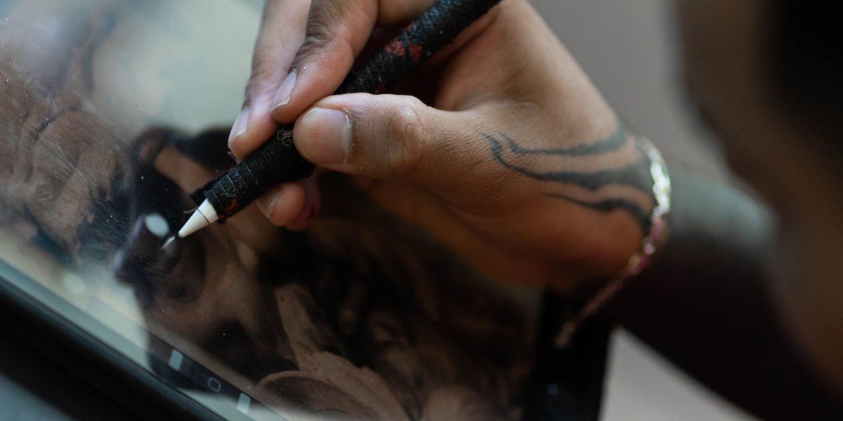 A creative professional using a stylus on a tablet or phone, illustrating the productivity and artistic potential of such tools.