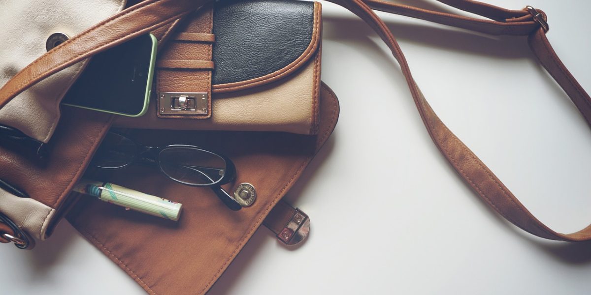A person seamlessly attaching a magnetic wallet to the back of their MagSafe-compatible phone case.