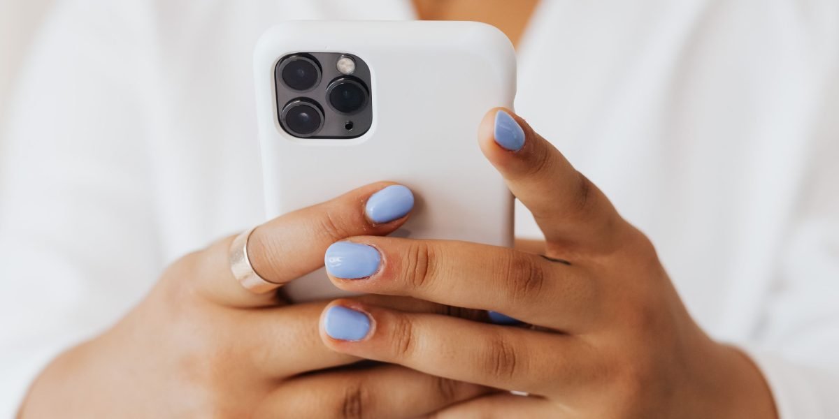 A person considering different color options for a new smartphone.