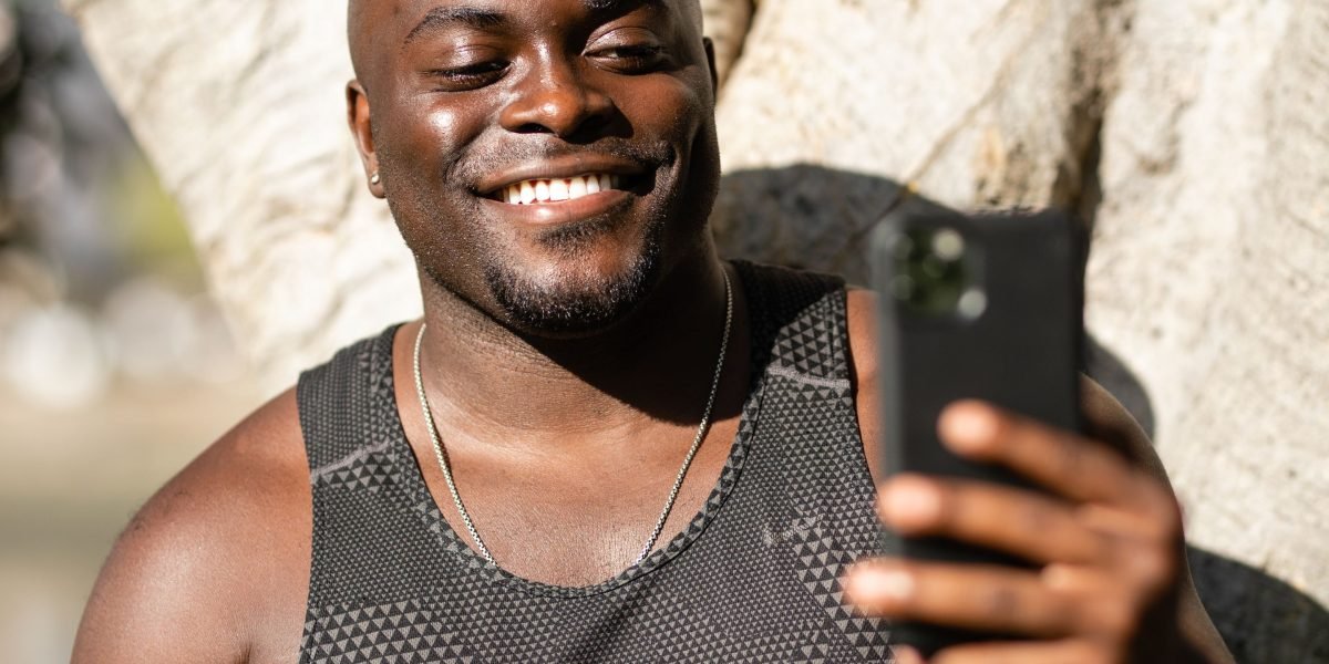 A person happily capturing a moment with their smartphone, highlighting improved camera capabilities.