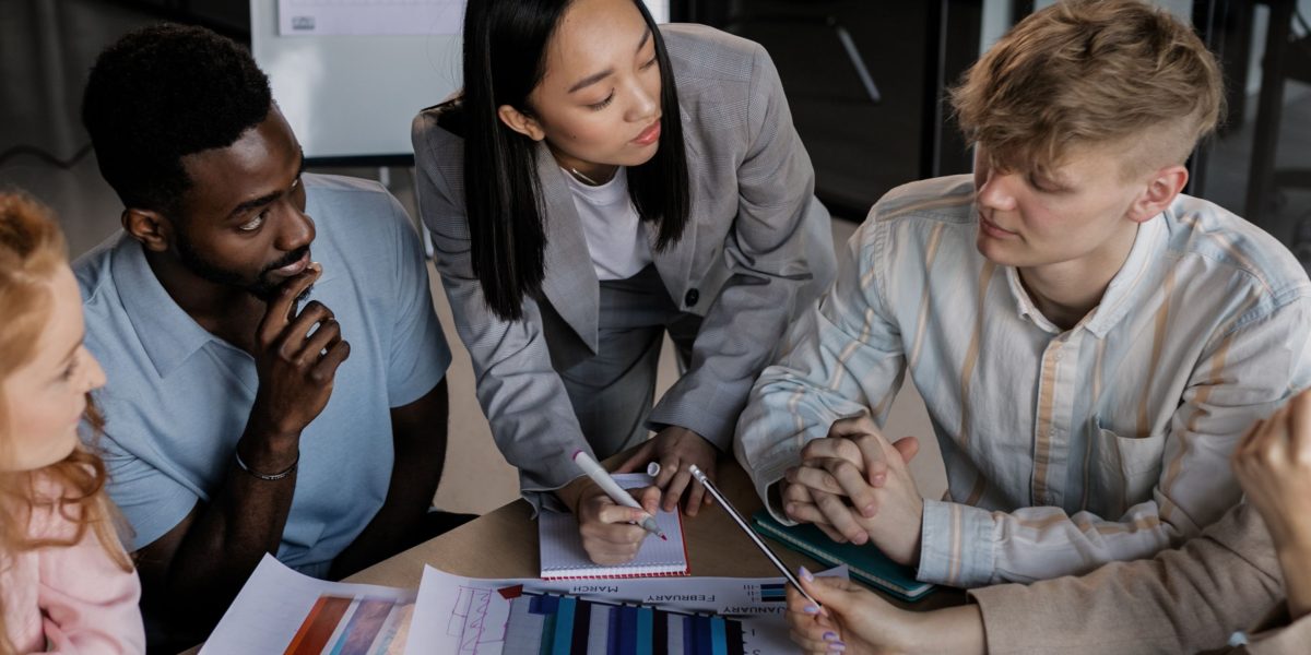 Diverse individuals collaborate to find solutions for complex ethical and regulatory challenges in technology.