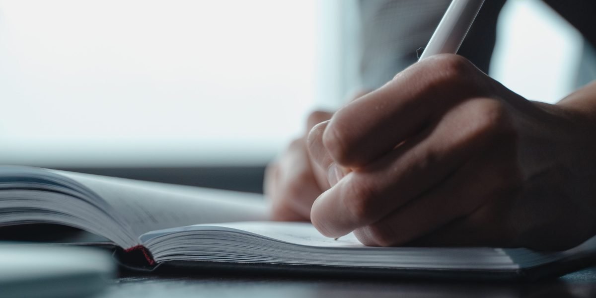 A person using a stylus on a tablet to take notes or draw during a productive work session.