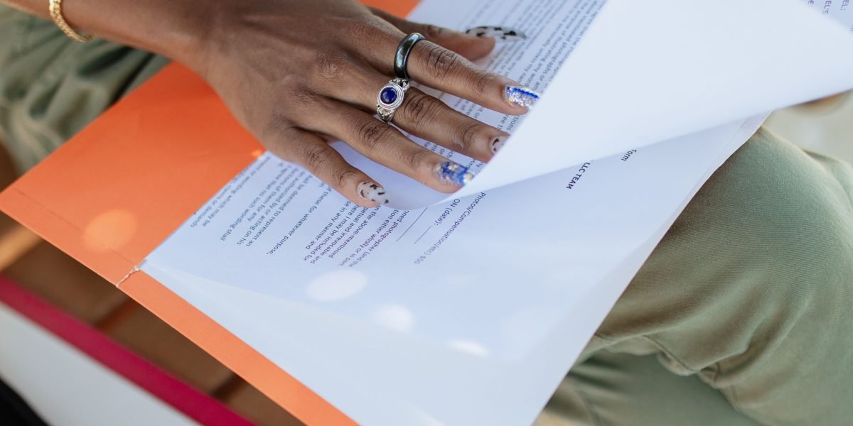 A person carefully reading through documents to understand warranty terms and return policies before finalizing a purchase.